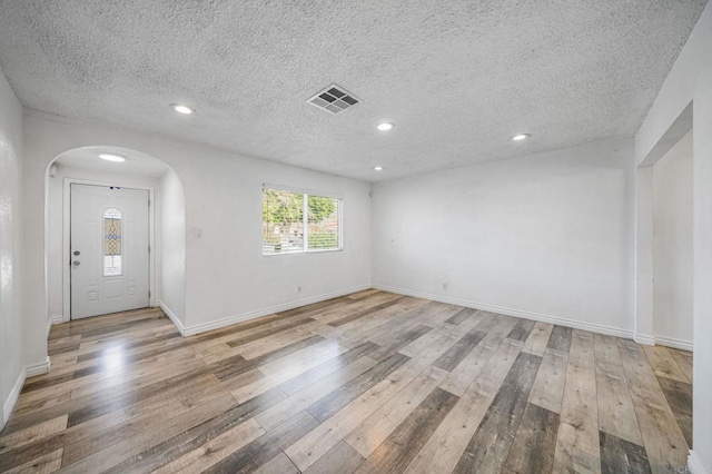 foyer featuring a textured ceiling and light wood-type flooring