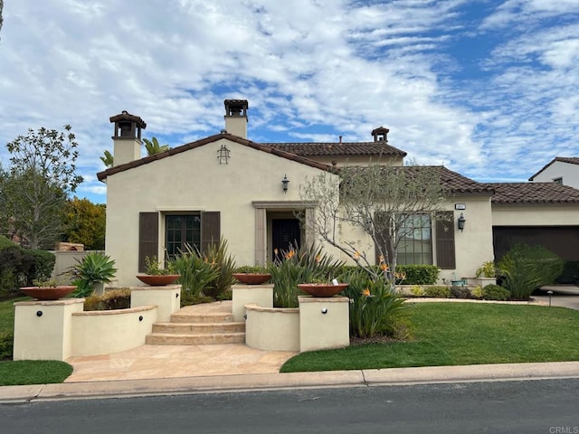 mediterranean / spanish-style home with a garage and a front yard