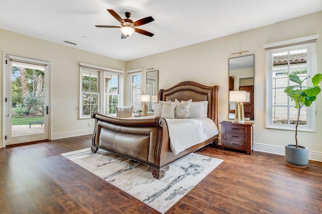 bedroom with multiple windows, access to outside, and dark hardwood / wood-style floors