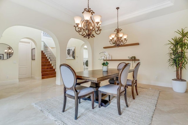 dining room with washer / clothes dryer, crown molding, and an inviting chandelier