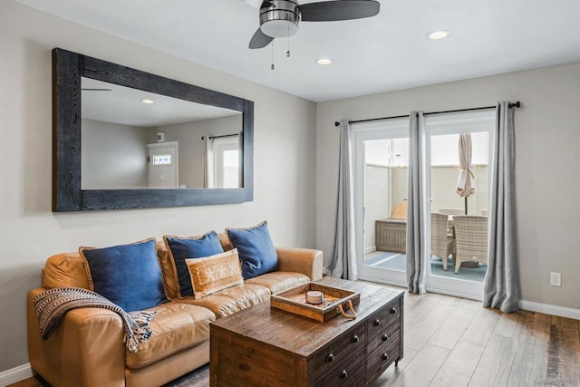 living room with ceiling fan and light hardwood / wood-style flooring