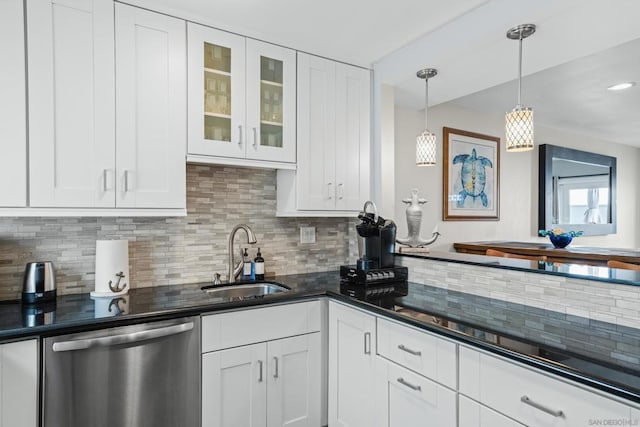 kitchen featuring decorative light fixtures, white cabinetry, sink, backsplash, and stainless steel dishwasher