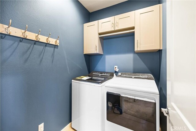 clothes washing area featuring cabinets and washing machine and dryer