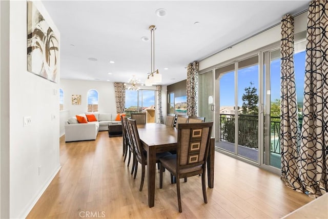 dining space featuring a notable chandelier and light wood-type flooring