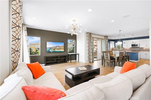 living room with a notable chandelier and light wood-type flooring