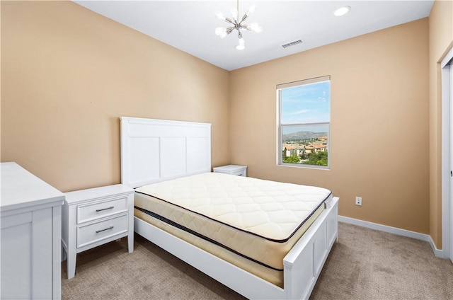 bedroom featuring a chandelier and light carpet