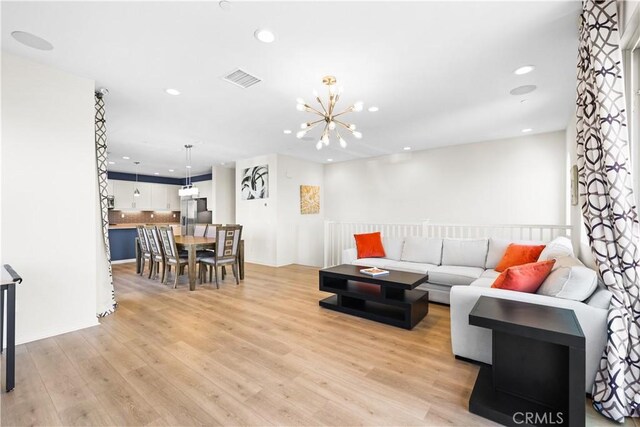 living room with a notable chandelier and light hardwood / wood-style flooring