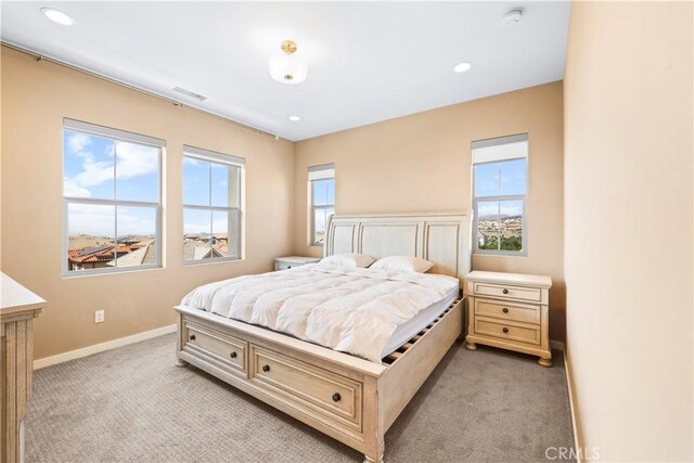 bedroom featuring multiple windows and light colored carpet