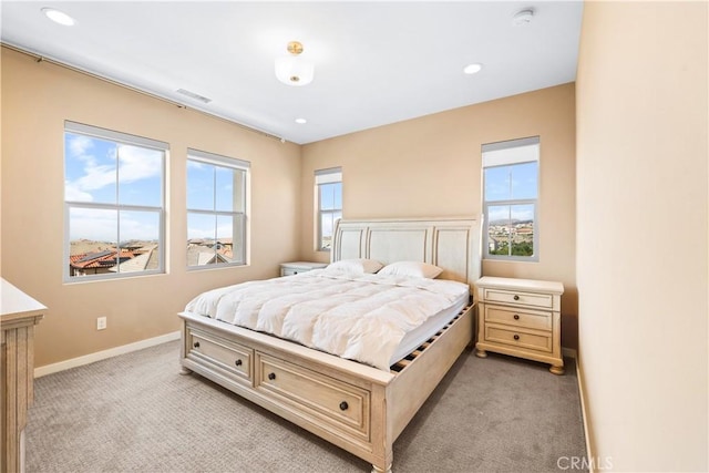 bedroom with multiple windows and light carpet