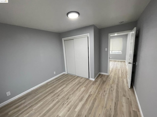 unfurnished bedroom featuring light hardwood / wood-style floors and a closet