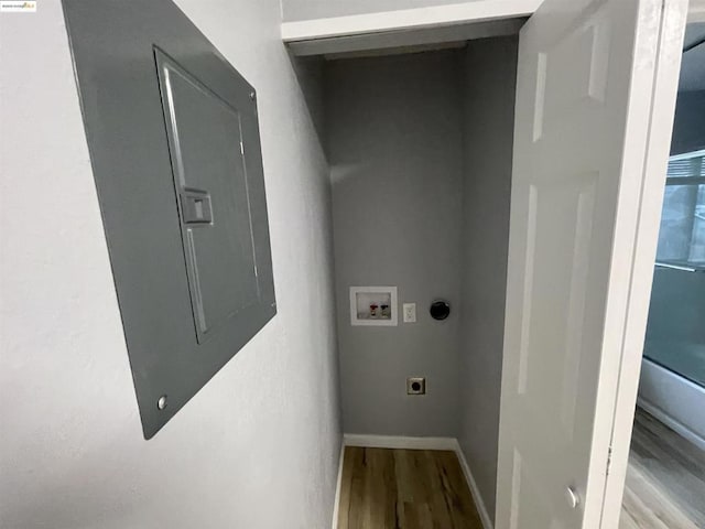 laundry room with hookup for a washing machine, light hardwood / wood-style floors, hookup for an electric dryer, and electric panel