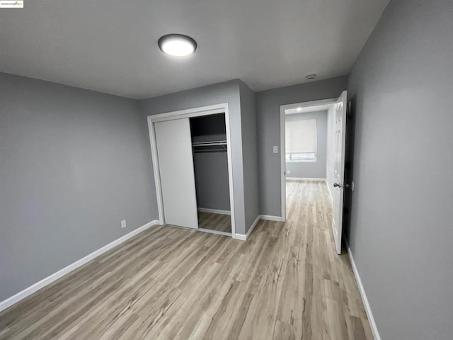 unfurnished bedroom with light hardwood / wood-style floors and a closet