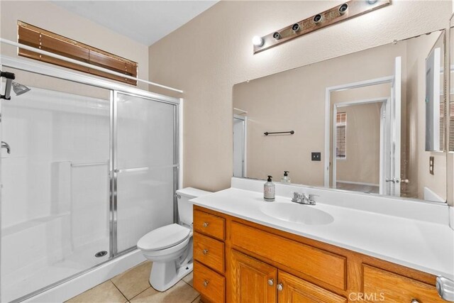 full bath with tile patterned flooring, vanity, toilet, and a shower stall