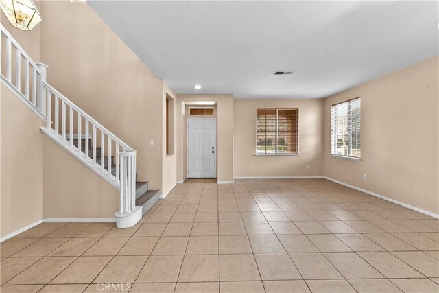 entrance foyer with light tile patterned floors, stairs, and visible vents