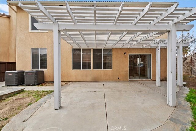 exterior space with central air condition unit, fence, and a pergola