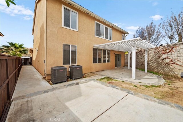 back of property with a patio area, stucco siding, a pergola, and cooling unit