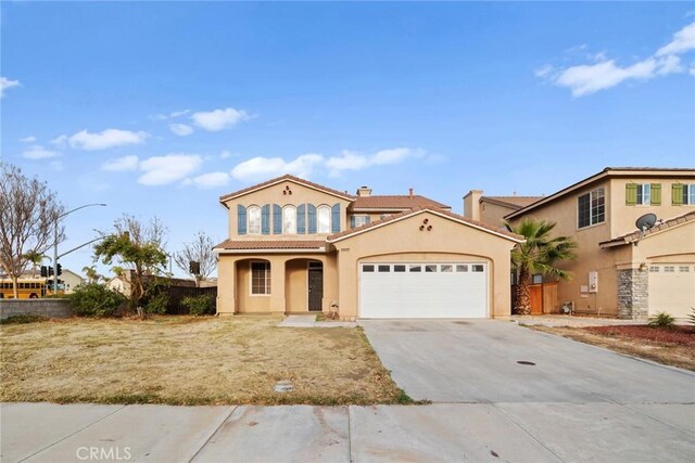 mediterranean / spanish-style house with fence, an attached garage, a tile roof, stucco siding, and concrete driveway