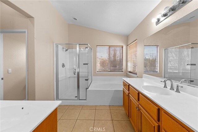 full bath with a sink, tile patterned flooring, two vanities, a shower stall, and lofted ceiling