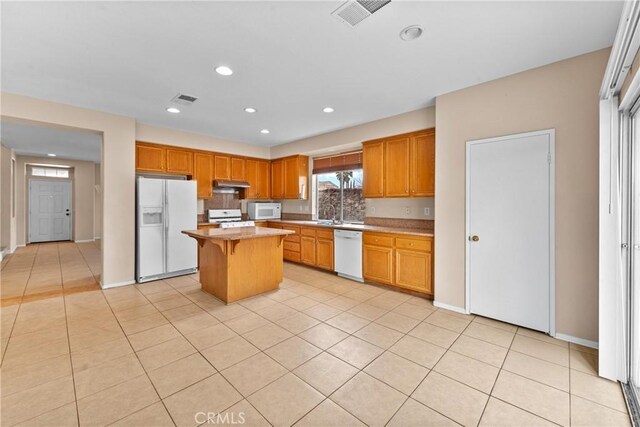 kitchen featuring visible vents, light tile patterned flooring, white appliances, light countertops, and under cabinet range hood