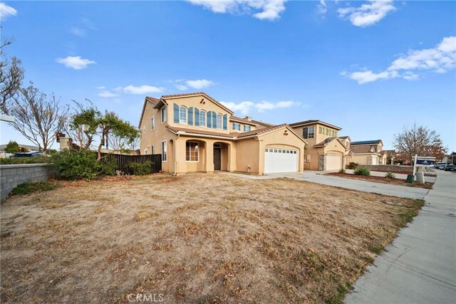 mediterranean / spanish home with fence, stucco siding, concrete driveway, and a garage