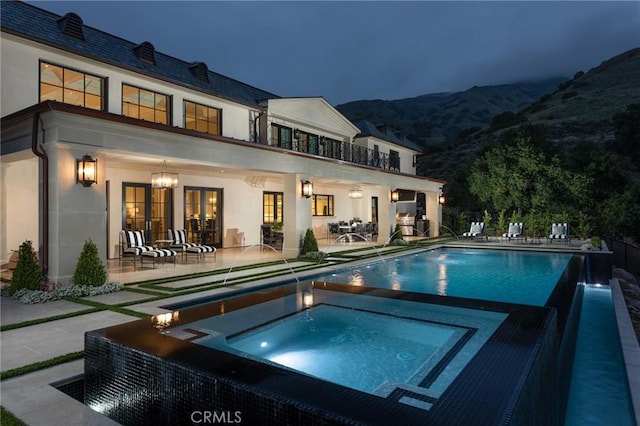 view of swimming pool featuring a patio, pool water feature, and an in ground hot tub