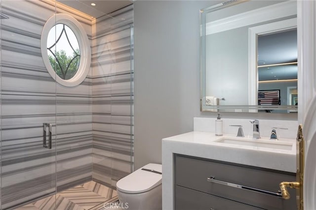 bathroom with vanity, a shower with shower door, and toilet