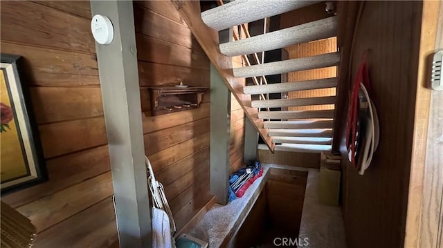 staircase featuring wood walls