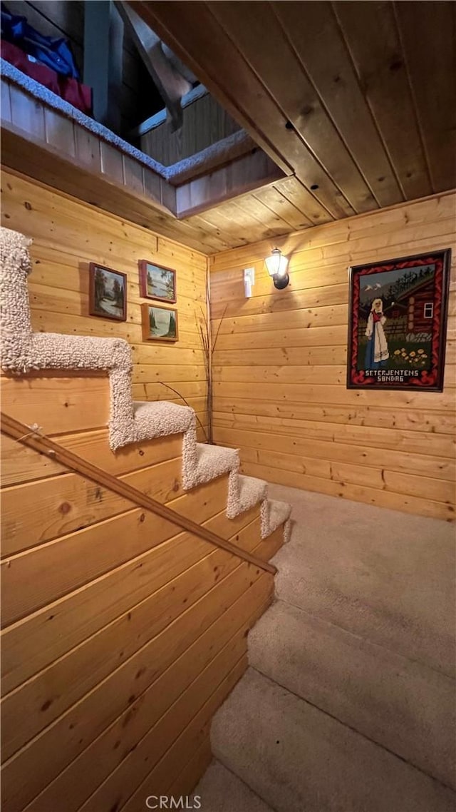 stairway featuring wood walls