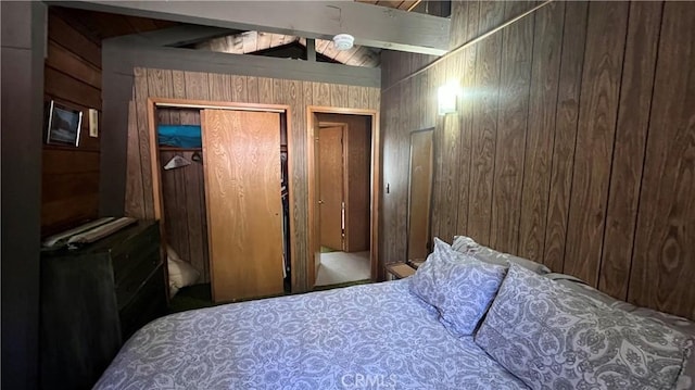 bedroom featuring lofted ceiling with beams, multiple closets, and wooden walls