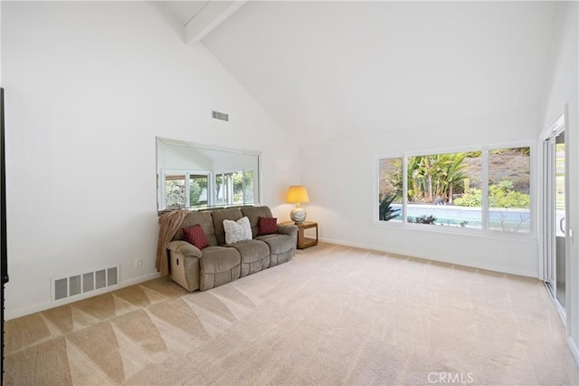 living room with beamed ceiling, plenty of natural light, and light colored carpet