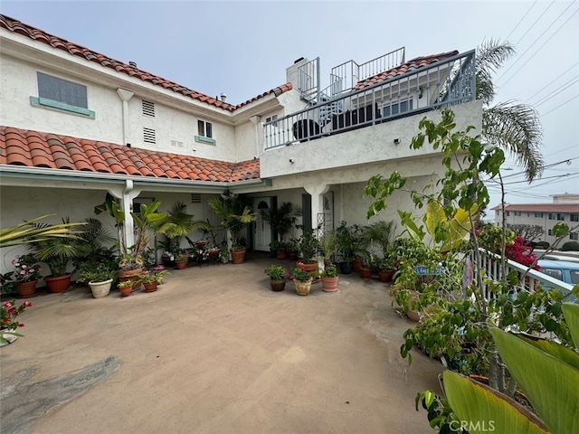 rear view of house featuring a patio and a balcony