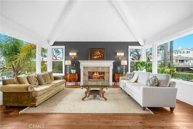 sunroom / solarium with plenty of natural light, a fireplace, and lofted ceiling with beams