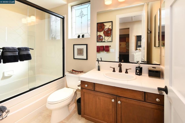 full bathroom featuring tile patterned flooring, bath / shower combo with glass door, vanity, and toilet