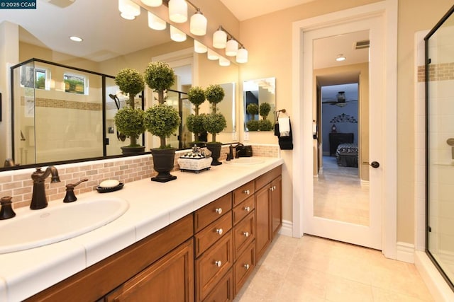 bathroom with tasteful backsplash, vanity, tile patterned flooring, and walk in shower