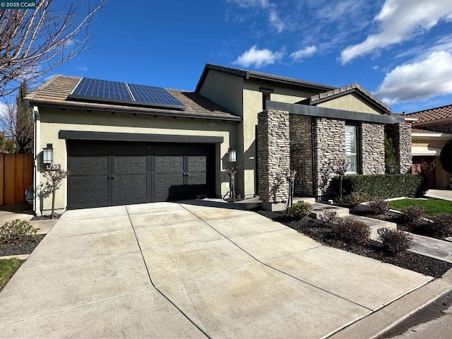 view of front of property with a garage and solar panels