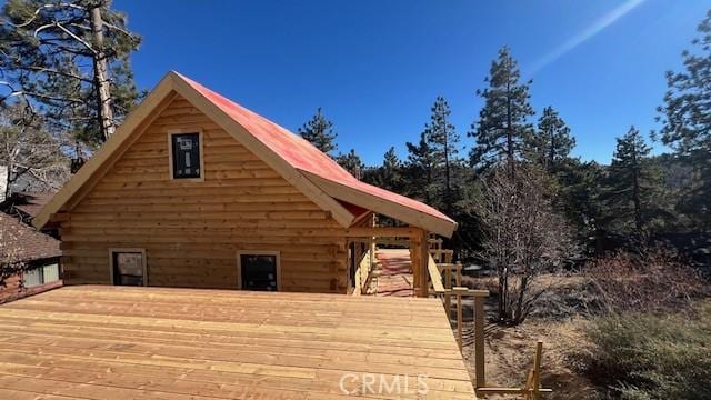 view of property exterior with a wooden deck