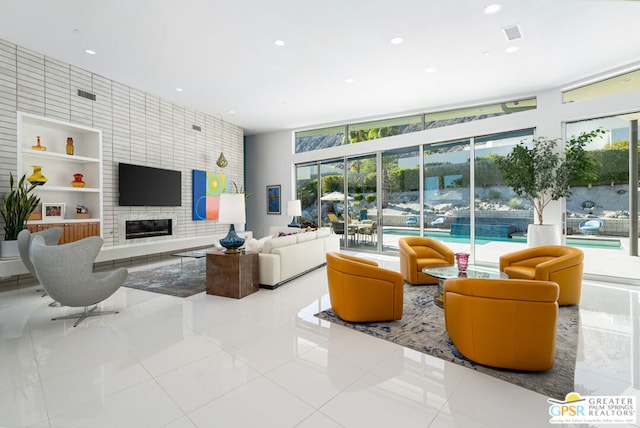 living room featuring a large fireplace and built in features