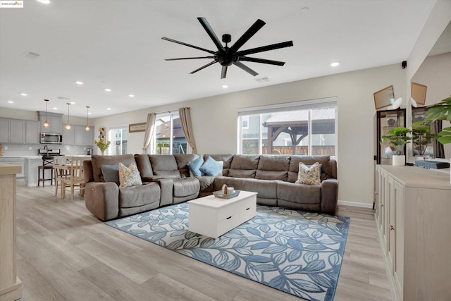 living room with ceiling fan and light hardwood / wood-style flooring