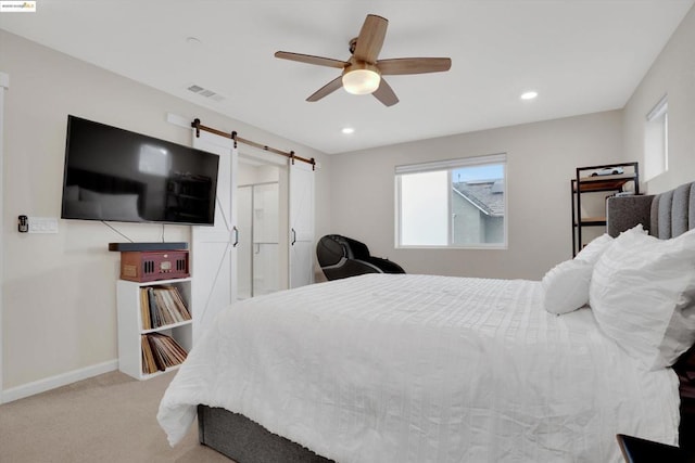 bedroom with a barn door, carpet, and ceiling fan