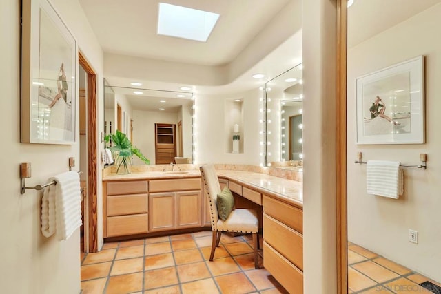 bathroom featuring vanity, a skylight, and tile patterned flooring