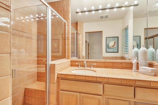 bathroom with vanity and a shower with shower door