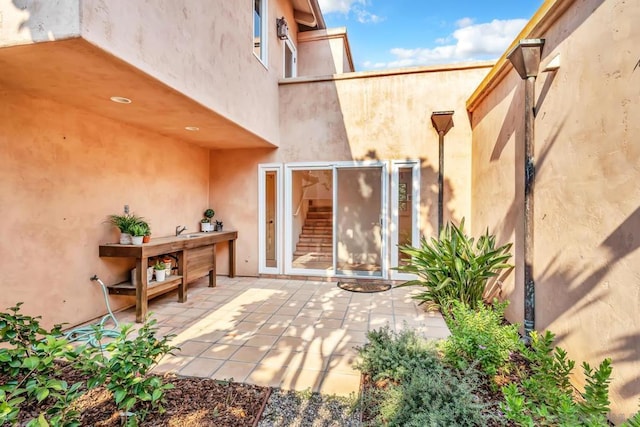 view of exterior entry with a patio