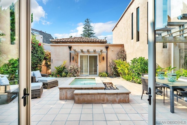 rear view of property with a patio, an outdoor structure, and an outdoor fire pit