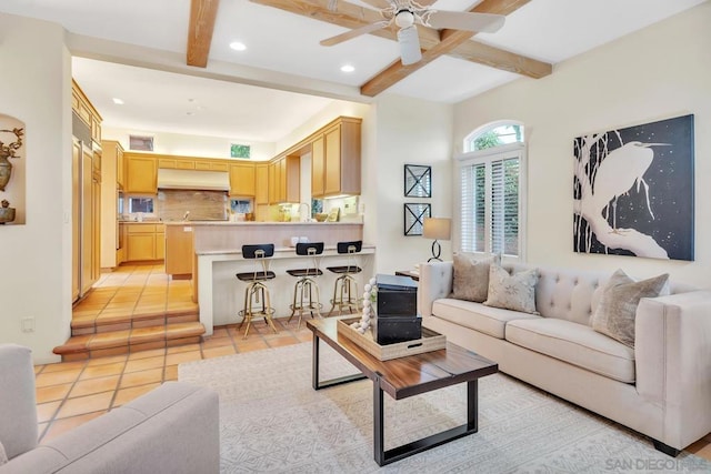 tiled living room with ceiling fan and beam ceiling