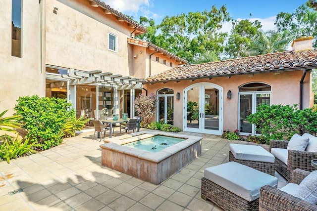 back of house featuring french doors, an outdoor hot tub, an outdoor hangout area, and a patio