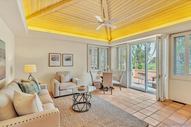 sunroom / solarium with wood ceiling, ceiling fan, and a raised ceiling