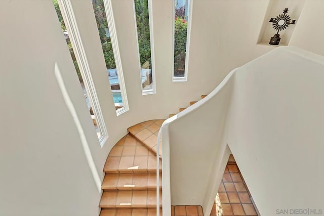 staircase with a healthy amount of sunlight and tile patterned flooring