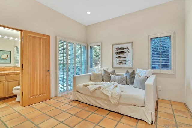 bedroom featuring ensuite bathroom, access to exterior, and light tile patterned floors