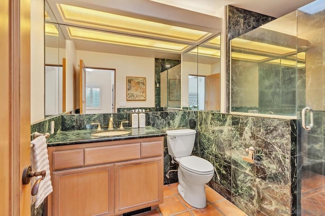 bathroom with tile walls, vanity, tile patterned floors, toilet, and walk in shower