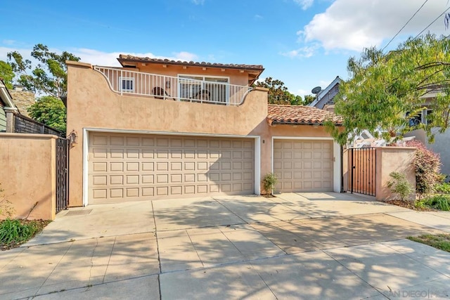 mediterranean / spanish-style home with a garage and a balcony